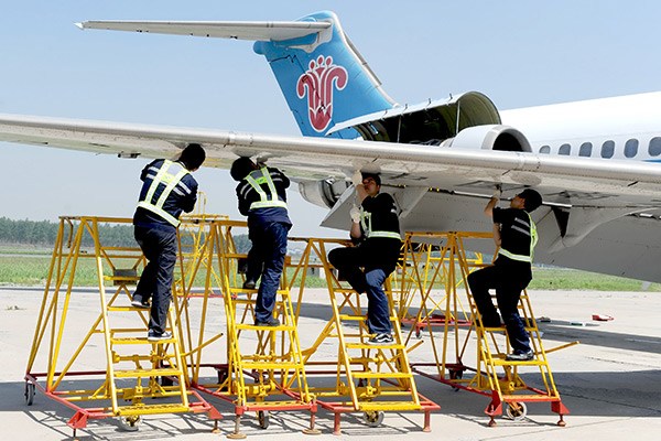 Technicians take part in a plane repair contest at the China Southern Airlines' maintenance and engineering base in Shenyang, Liaoning province. (Photo/Xinhua)