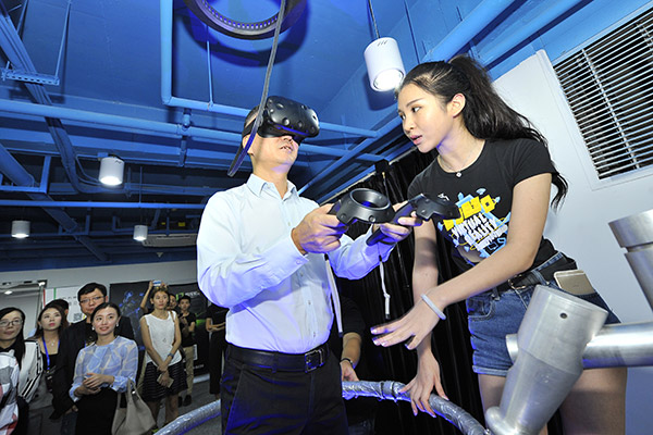An executive from internet giant Tencent Holdings Ltd experiences a pilot virtual reality device at an entrepreneurship event in Fuzhou, East China's Fujian province. (Photo/China Daily)