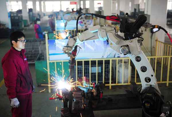 A robot performs a soldering job at an auto parts manufacturing company in Fuyang, Anhui province. WANG BIAO / FOR CHINA DAILY