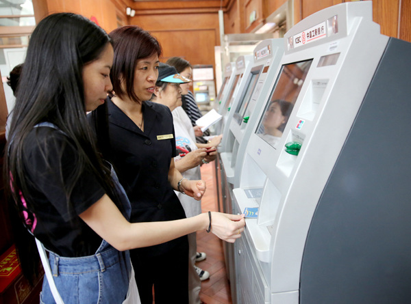 Customers use facilities at an outlet of Industrial & Commercial Bank of China Ltd in Beijing. LI HE / FOR CHINA DAILY