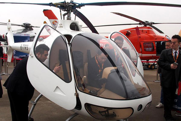 Visitors look at a business plane exhibited during 2017 Asian Business Aviation Conference & Exhibition (ABACE) at Hongqiao International Airport in East China's Shanghai, April 11, 2017.
