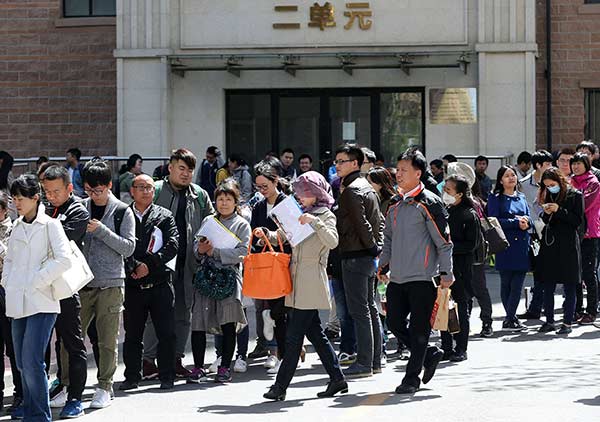 People wait in line to apply for public rental homes in Beijing's Chaoyang district on Tuesday.Wang Zhuangfei / China Daily