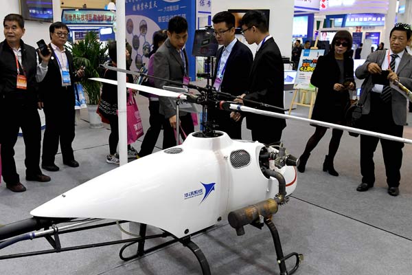 Visitors look at a drone displayed at a high-tech expo held recently in Zhengzhou, Henan province. (Photo/Xinhua)
