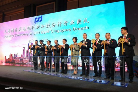 Shanghai Pudong Development Bank's President Liu Xinyi (4th R) and Senior Miniser of State for Singapore's Ministry of Trade and Industry Sim Ann (5th R) attend the opening ceremony of the Singapore branch of Shanghai Pudong Development Bank in Singapore on April 12, 2017. (Xinhua/Then Chih Wey)