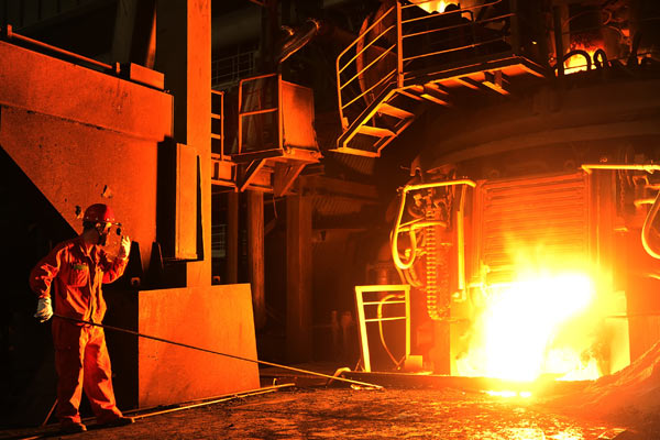 A worker checks molten steel at an iron and steel plant in Dalian, Liaoning province. Central State-owned enterprises saw their total revenues surge 19.2 percent to reach 6 trillion yuan in the first quarter of the year. (Photo by Liu Debin/For China Daily)