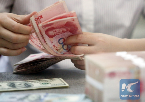 A worker counts Chinese currency Renminbi (RMB) at a bank in Linyi, east China's Shandong Province, Aug. 11, 2015. (Xinhua/Zhang Chunlei)