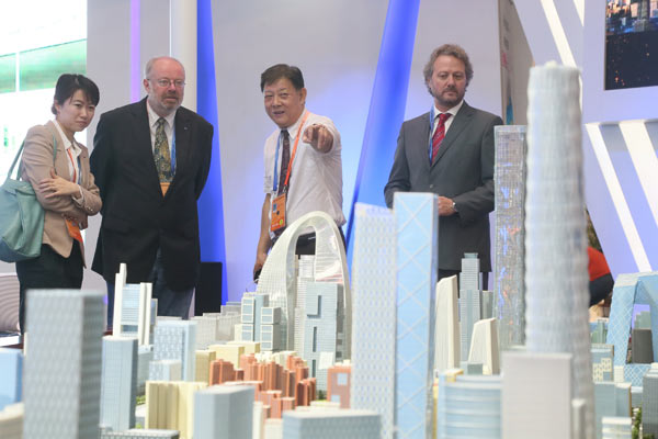 Foreign visitors look at the model of the Beijing CBD district at a property industry expo. (Photo provided to China Daily)