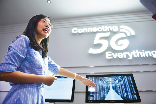 An employee from China Mobile Ltd explains 5G technology at an exhibition hall in Beijing. (Photo/Xinhua)