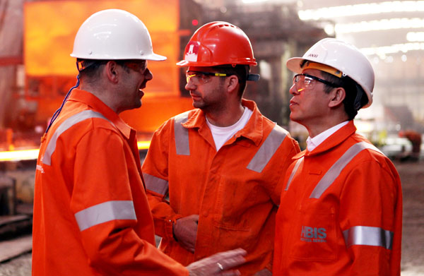 Hesteel Serbia employees discuss production techniques with a member of the Chinese management team. (Photo by Fu Jing/China Daily)