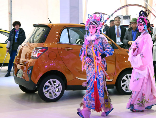 Performers in traditional local opera costumes attend a new energy vehicle show in Jinhua, Zhejiang province. (Photo by Ge Yuejin/For China Daily)