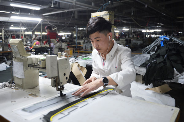 A worker at a local clothes manufacturing factory in Rongcheng county is also a pop music lover. (Photo by Leo Chan/For China Daily)