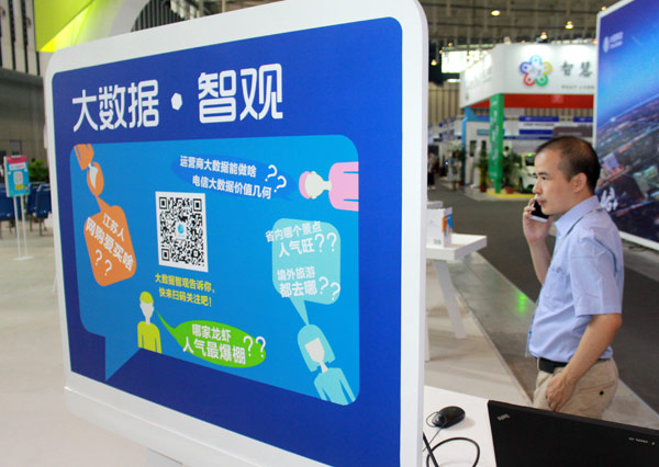 A man answers his mobile phone at a booth promoting big data during an industry expo in Nanjing, capital of Jiangsu province. ZHEN HUAI / FOR CHINA DAILY