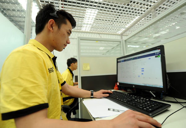 An employee of Guiyang Huochebang Technology Co Ltd communicates with customers at a digital hub in Guiyang, Guizhou province, May 23, 2016. (Photo/Xinhua)