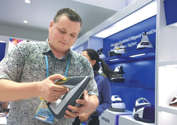 A foreign merchant tries a steam iron at the Canton Fair, which ended on Friday in Guangzhou, Guangdong province. (Photo/China Daily)
