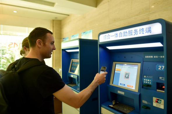 A foreigner pays his medical fees by scanning the QR code on a machine at the Second Affiliated Hospital of Zhejiang University School of Medicine in Hangzhou, Zhejiang province, on April 14, 2017. Photo/Xinhua