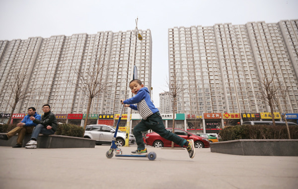 A boy plays near a property project in Langfang, Hebei province. WANG JIJIA / FOR CHINA DAILY