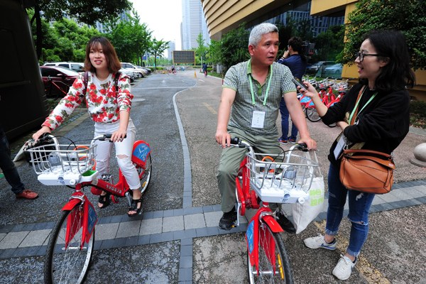 Riders test newly designed rental bicycles that use electrical power to supplement human pedaling, in Hangzhou, Zhejiang province, on Tuesday. Su Bin / For China Daily