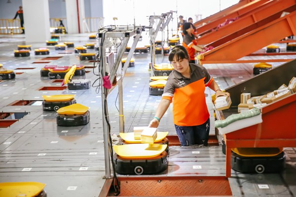 Employees of a delivery service company use robots to sort parcels in Yiwu, Zhejiang province. XINHUA