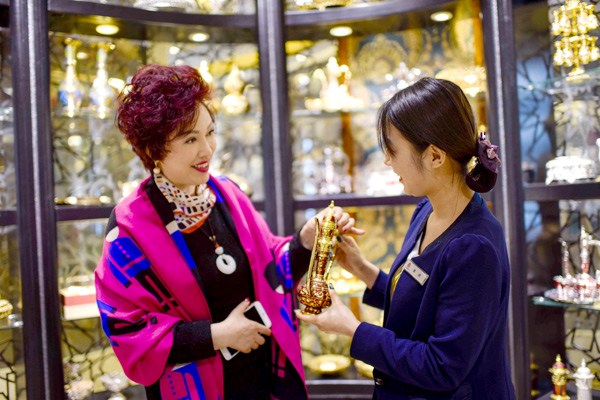 A tourist buys bronzeware made in Pakistan at the Grand Bazaar in Urumqi, capital of the Xinjiang Uygur autonomous region. XINHUA