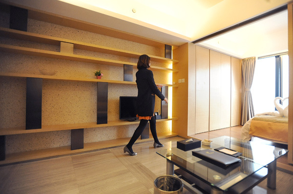 A sales clerk from Tujia shows the interior design and layout of a short-term home in Chengdu. WANG TIANZHI / FOR CHINA DAILY