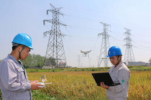Technicians use an intelligent drone to inspect a transformer in Chuzhou, Anhui province. (Photo/China Daily)