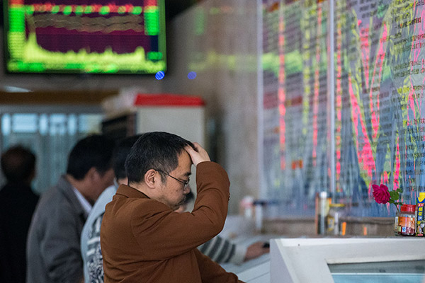 Investors check stock prices at a brokerage in Nanjing, Jiangsu. Passive investing tools like index funds are now popular among Chinese investors. (Photo/China Daily)