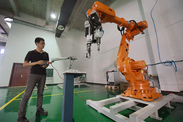 A startup entrepreneur tests a robot at an innovation center in Langfang, Hebei province. Photo/Xinhua