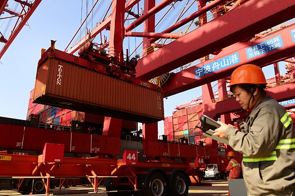 A worker monitors container operations at Zhoushan port in Ningbo, Zhejiang province. (Photo/China Daily)