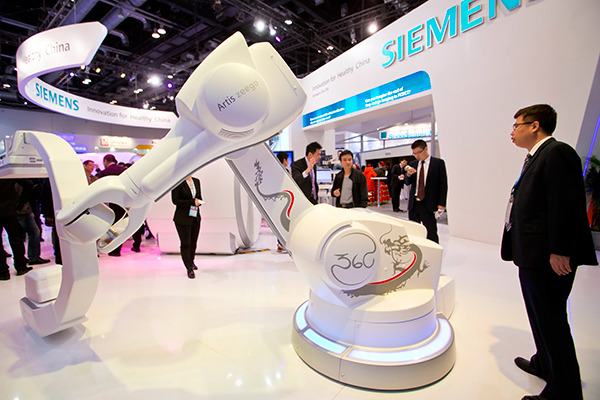 A man examines Siemens' healthcare facilities at an industry expo in Beijing. (Photo/China Daily)