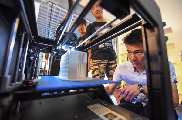 A student prints souvenirs using a 3D printer at an on-campus innovation center in Xinyu, Jiangxi province. (Zhao Chunliang / For China Daily)