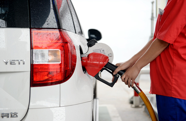 A worker fills up a car with fuel at a gas station in Xi'an city, Shaanxi province, June 9, 2017. (Photo/Xinhua)