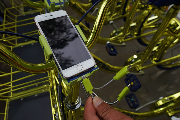 Coolqi's new golden bikes, shown here in Beijing, have charging equipment for phones. (Photo/China Daily)