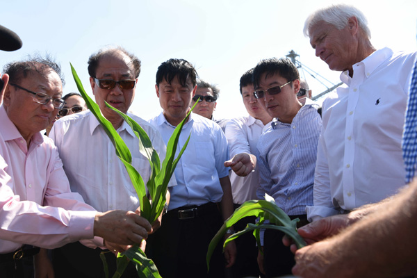 The dean of Renmin University of China's School of Journalism, Zhao Qizheng (second from left), and Guo Weimin (center), vice-minister of China's State Council Information Office, talk with farm owner Rick Kimberley. Representatives of Chinese leading think tanks visited the Kimberley Farms in Iowa on Sunday. (Photo//China News Service)