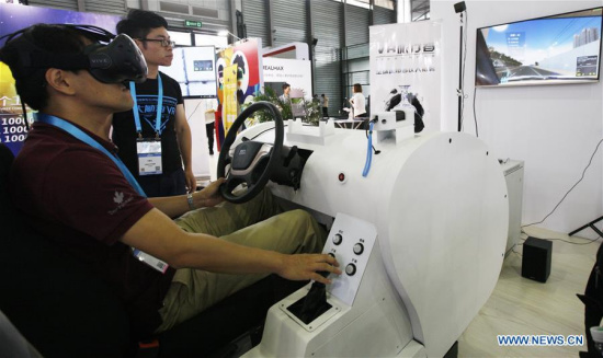 A visitor tries a virtual driving system that can be used by driving schools during the 2017 CES (Consumer Electronics Show) Asia in Shanghai, east China, June 7, 2017. (Xinhua/Fang Zhe)
