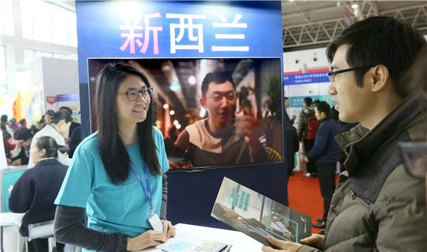 A visitor (right) asks about studying in New Zealand during an education exhibition in Beijing in March. A Jing / For China Daily