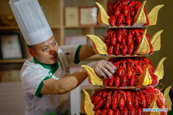 A cook prepares his Tower of Lobsters at a lobster cuisine championship held in Xuyi County of Huaian, east China's Jiangsu Province, June 3, 2017. (Xinhua/Zhou Haijun)