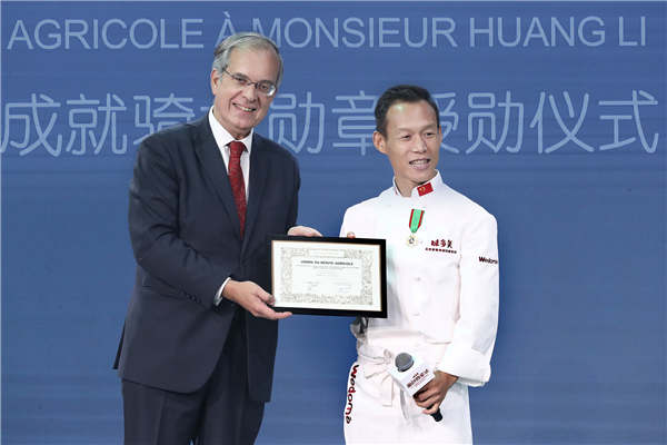 French Ambassador Maurice Gourdault-Montagne presents Huang Li with the Knight of the Order of Agricultural Merit (France) earlier this month.
