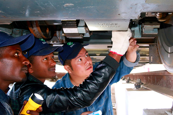 Qiu An, a trainer at Shenzhen Metro, shares rail vehicle maintenance tips with two local colleagues in Addis Ababa, the capital of Ethiopia. (Photo provided to China Daily)