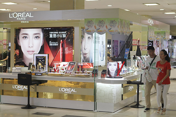 Customers walk past a L'Oreal counter at a shopping center in Rizhao, Shandong province. (Photo/China Daily)