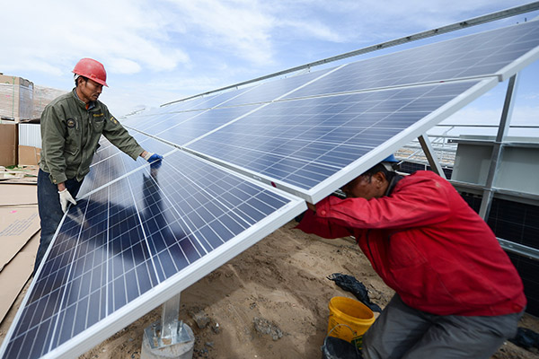 Workers install solar panels in Golmud, Qinghai province. (Photo/Xinhua)
