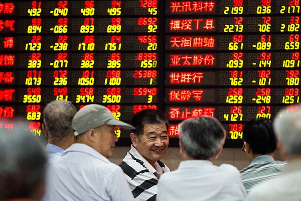 Investors examine stock prices at a security brokerage in Nanjing, capital of Jiangsu province. (Photo/China Daily)