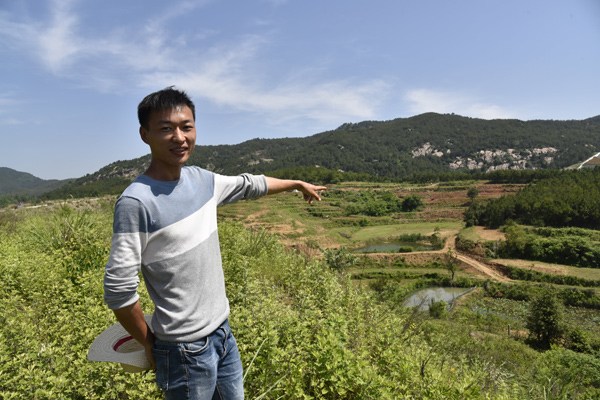 Hu Zhongqing introduces his ecological agricultural garden in Macheng, Hubei province. (Photo by Wu Yan/China Daily)
