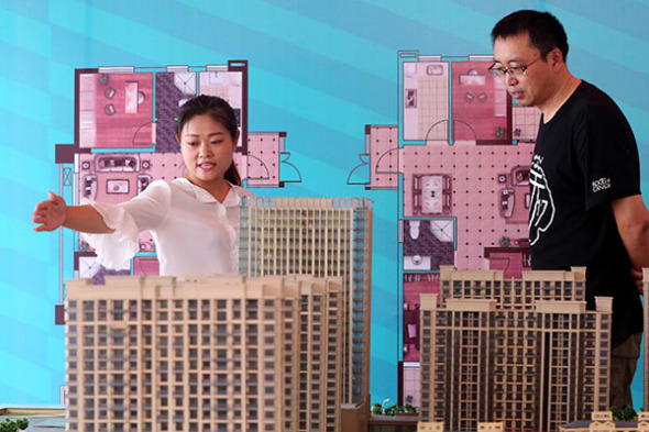 Denizens of Huai'an, Jiangsu province, look at a property model at an autumn expo in Sept 2016. (Provided to China Daily)