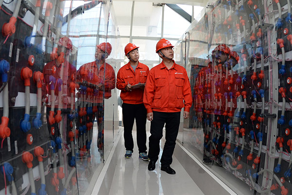 Staff of Goldwind check the operation of the intelligent power producing system in Yancheng, Jiangsu province. (Photo/Xinhua)