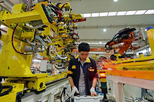 A technician of an industry park in Hefei, Anhui province, tests welding equipment to be exported to Belarus. (Photo/China Daily)