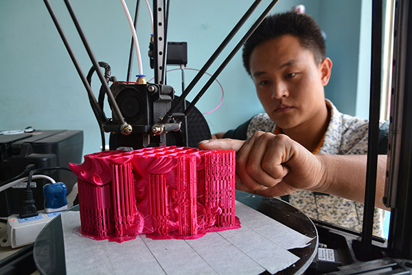 A man operates a 3-D printer at a company in Rizhao, Shandong province. (Photo/China Daily)