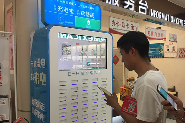 A customer tries a shared power bank at a shopping center in Jinan, Shandong province. (Photo/China Daily)