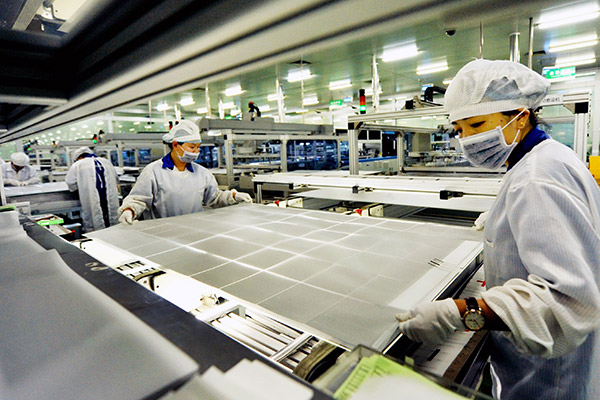 Two women operate on a production line of a solar panel making company in Shangrao, Jiangxi province. (Photo/China Daily)