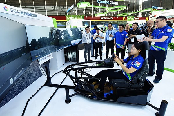 A woman demonstrates remote driving technology based on 5G during the 2017 Mobile World Congress in Shanghai, June 28. (Photo/China Daily)