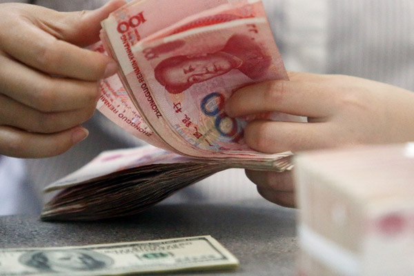 A worker counts Chinese currency renminbi at a bank in Linyi, East China's Shandong province, Aug 11, 2015. (Photo/Xinhua)